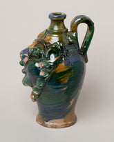 View from the side of the Apotropaia Medium Head Jug Two on light color background.