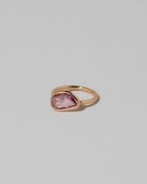 View from the side of the Gusher Pink Sapphire Ring 011 on light color background.