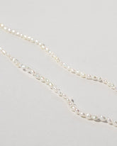 Closeup details of the White Oval Seed Pearl Bracelets on light color background.