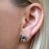 product_details::Juniper Stud Earrings styled with Huggie Gold Diamond Snack Hoop Earrings on model.