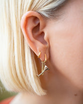 Dirty Martini Charm and Joint Charm paired with Gold Poppy Flower Bud Hoop Earrings and styled with Huggie Gold Solid Snack Hoop Earrings on model.