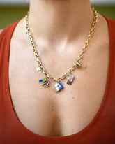 Saltine Cracker Charm, Sardine Can Charm, Instant Ramen Charm, Chocolate Bar Charm and Dirty Martini Charm paired with Gold Endless Clasp Bracelets worn as a a necklace on model.