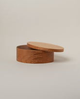 Detail view of the Rikke Falkow Medium Cherry Wood Oval Box on light color background.