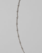 Closeup details of the CRZM Sterling Silver Double Helix Chain Necklace on light color background.