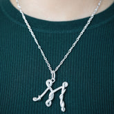 product_details::CRZM Sterling Silver Infinity Chain Necklace and CRZM Letter M Large Sterling Silver Letter Charm on model.