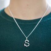 product_details::CRZM CRZM 2mm Sterling Silver Short Loop Chain Necklace and CRZM Letter S Medium Sterling Silver Letter Charms on model.