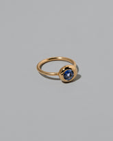 View from the side of the past version Blue Sapphire Level Ring on light color background.
