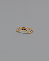 View from the side of the Gold Thin Fluctuating Band on light color background.