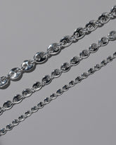 Closeup details of the CRZM Sterling Silver Bedrock Mini Necklace, Sterling Silver Bedrock Medium Necklace, and Sterling Silver Bedrock Necklace on light color background.