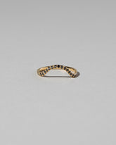 Gold Pavé Black Diamond Curve Band on light color background.