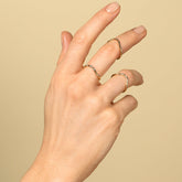 product_details::Gold Five Stone Mini Curve Bands on model.