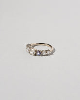 View from the side of the Diamond & Sapphire Line Cluster Ring on light color background.