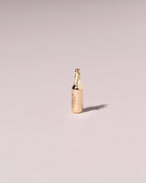 Bottle of Beer Charm on light color background.