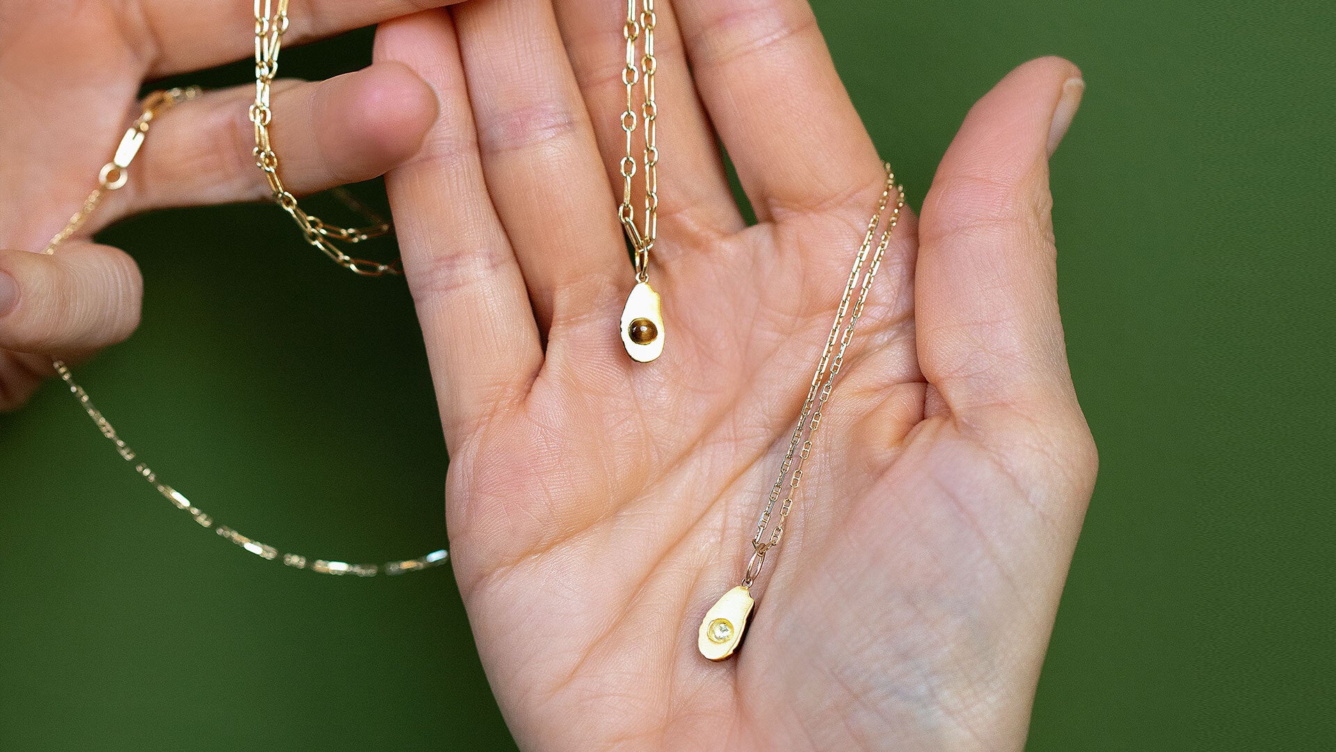 Hot Dog Chain Necklace with the 'pitted' Halved Avocado Charm and Petite Diamond Cut Chain Necklace with the 'pitless' Halved Avocado Charm on model.