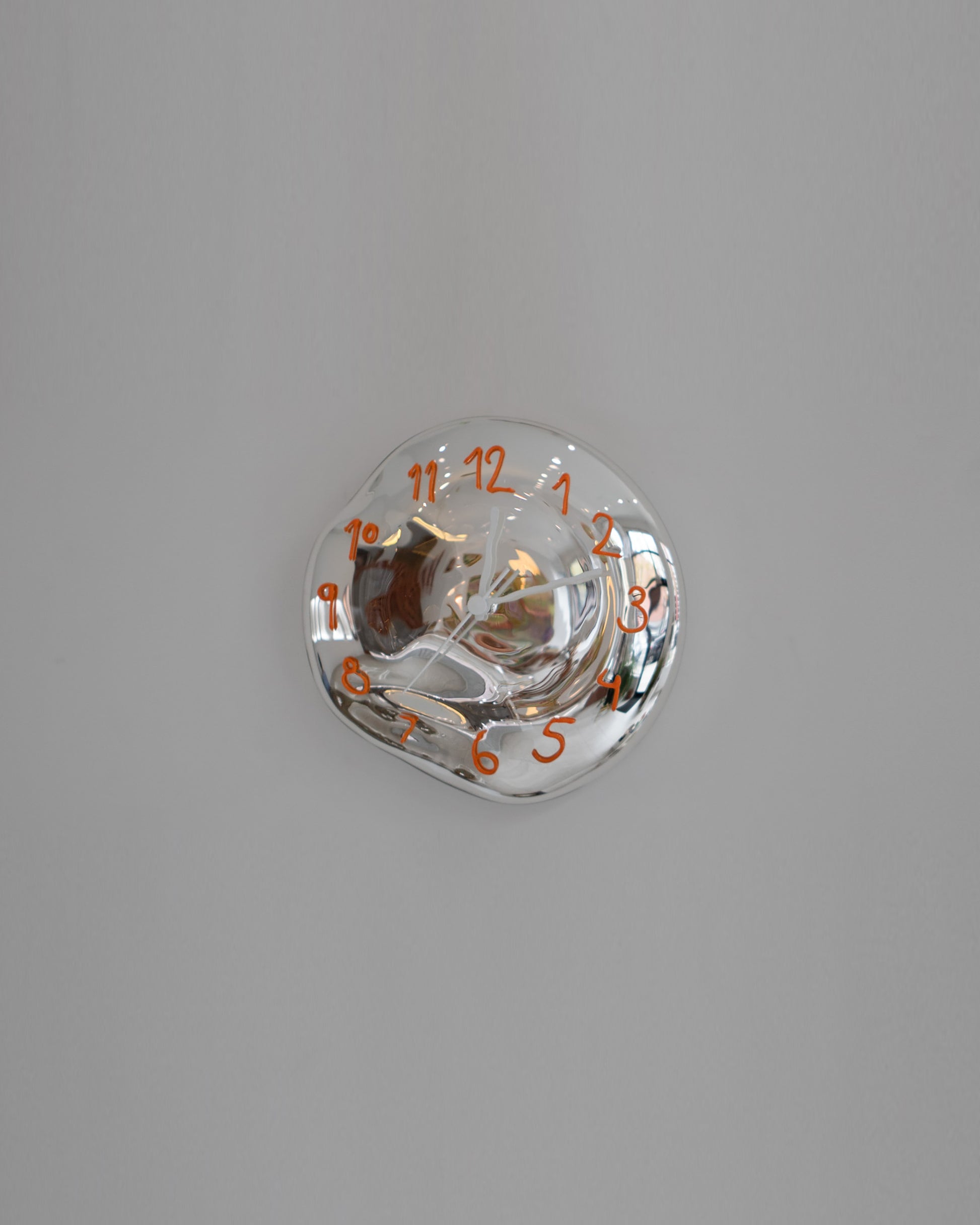 Silje Lindrup White Hands Two Orange Glass Wall Clock on light color background.