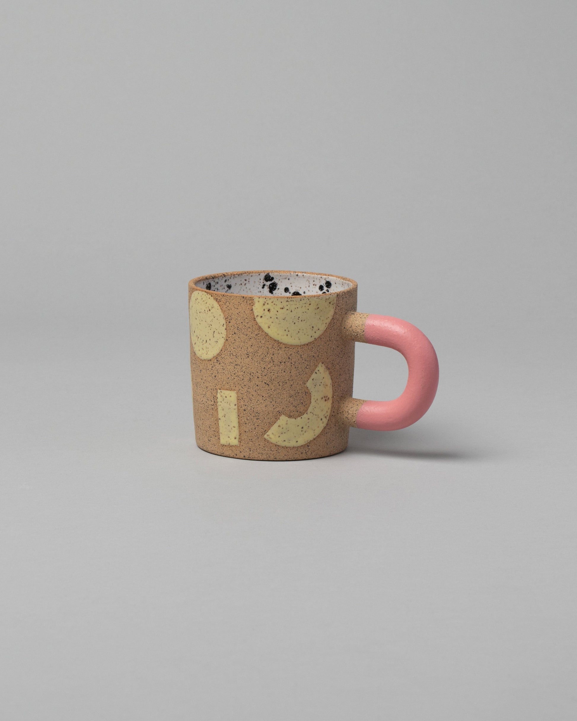 Recreation Center Yellow Shapes & Pink Handle Shapes Mug on light color background.