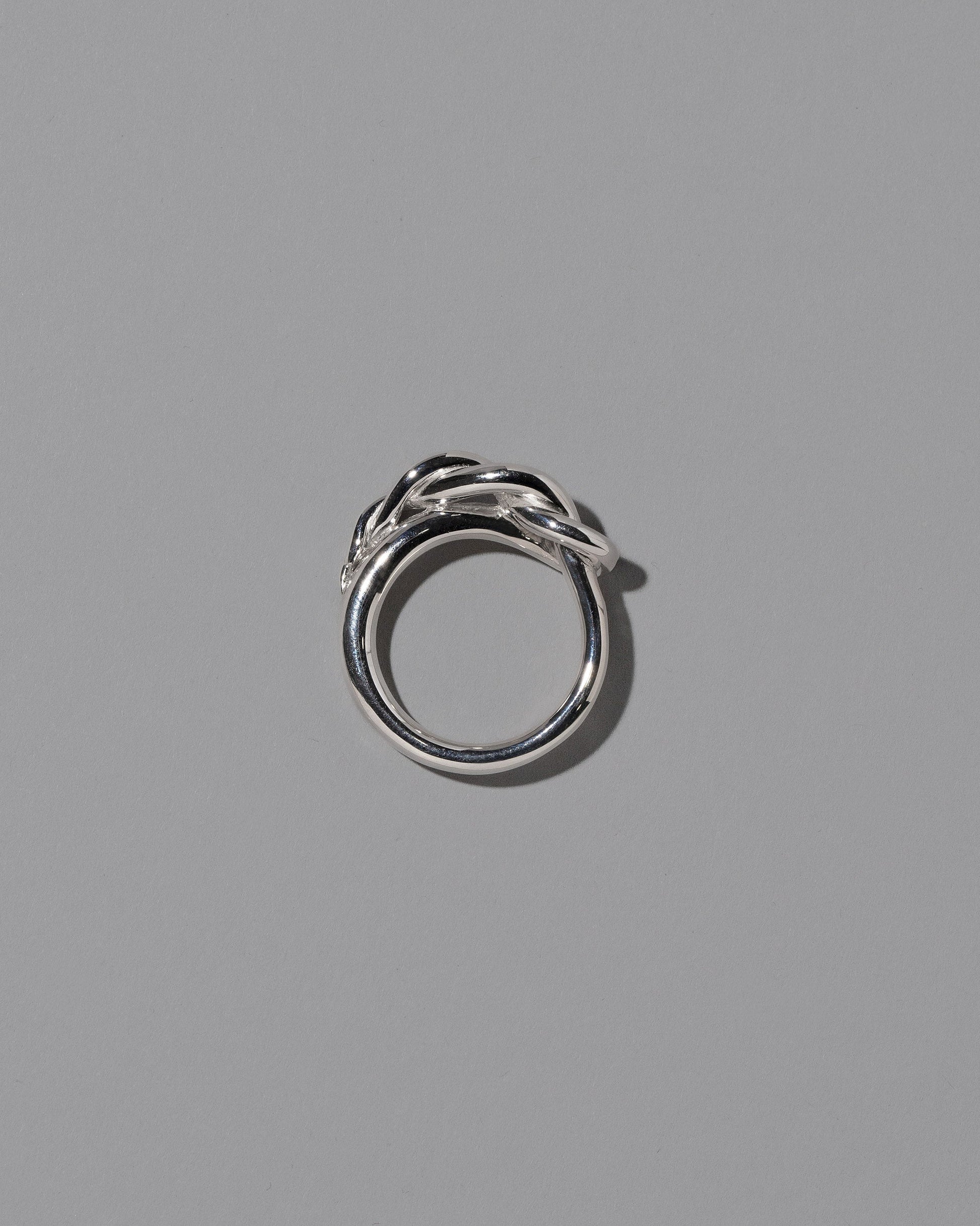 View from the side of the CRZM Sterling Silver Ophiolite Ring on light color background.