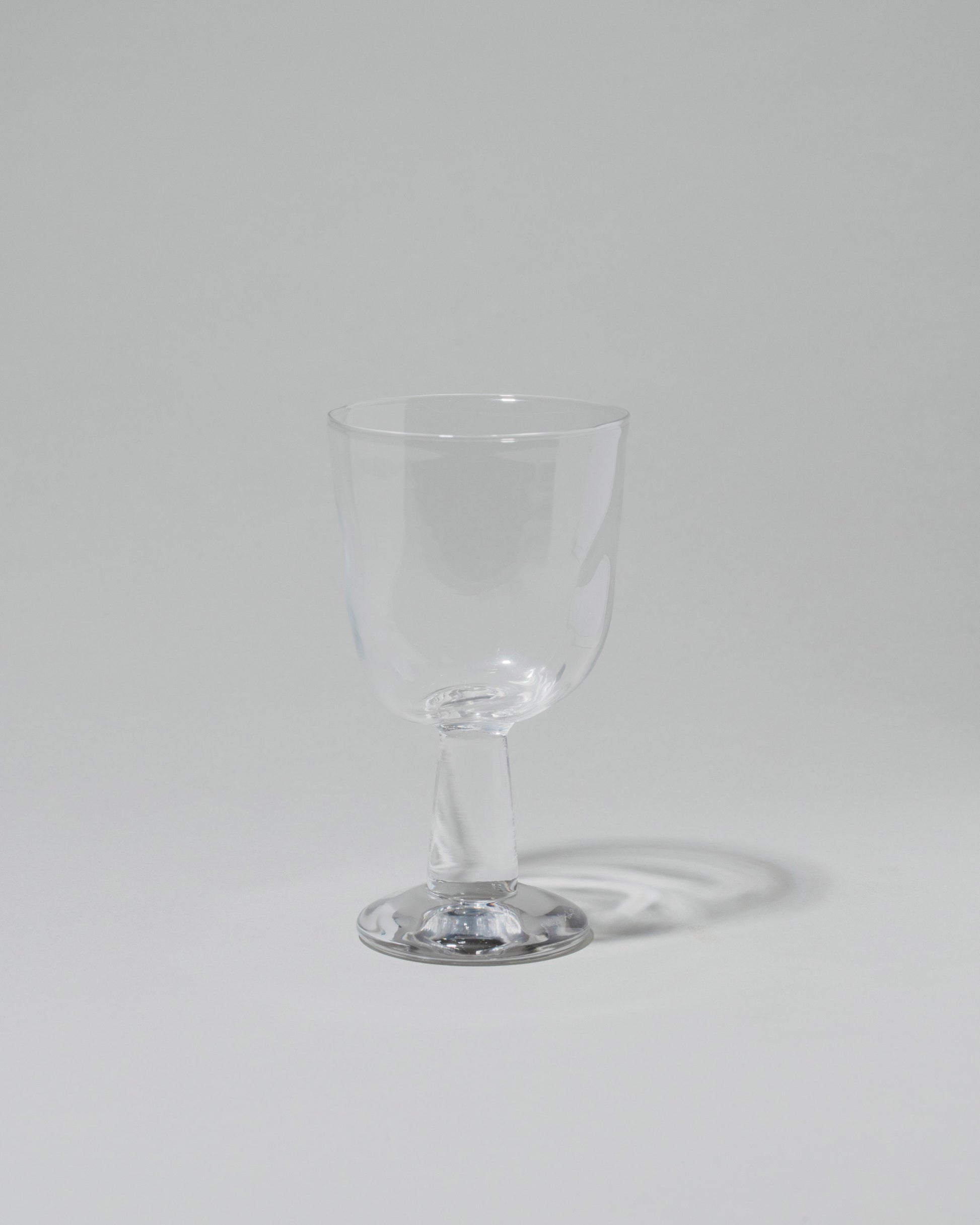 Silje Lindrup Twisted Liqueur Glass on light color background.