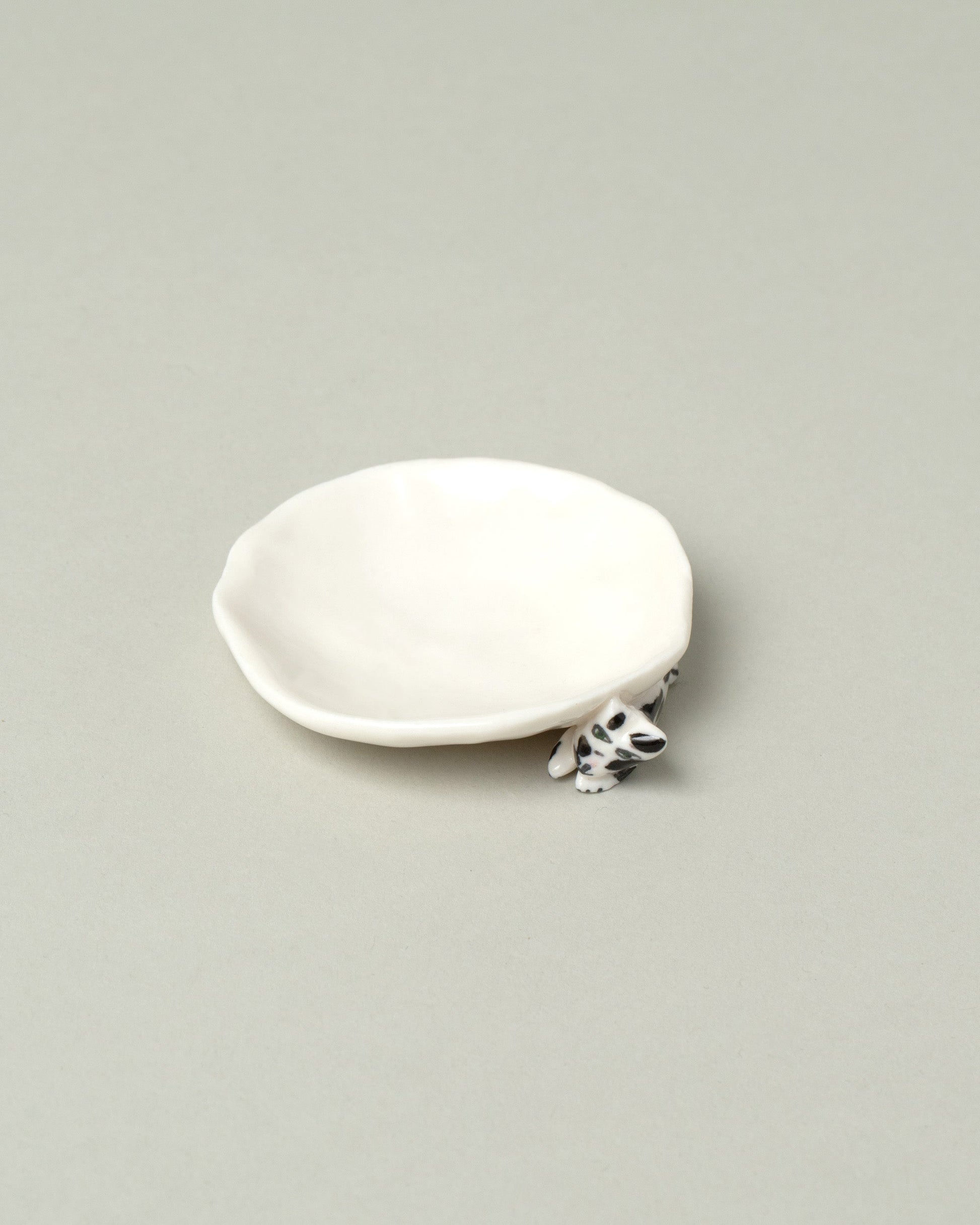 Closeup detail of the Eleonor Boström Black Spots Mini Cat Dish on light color background.