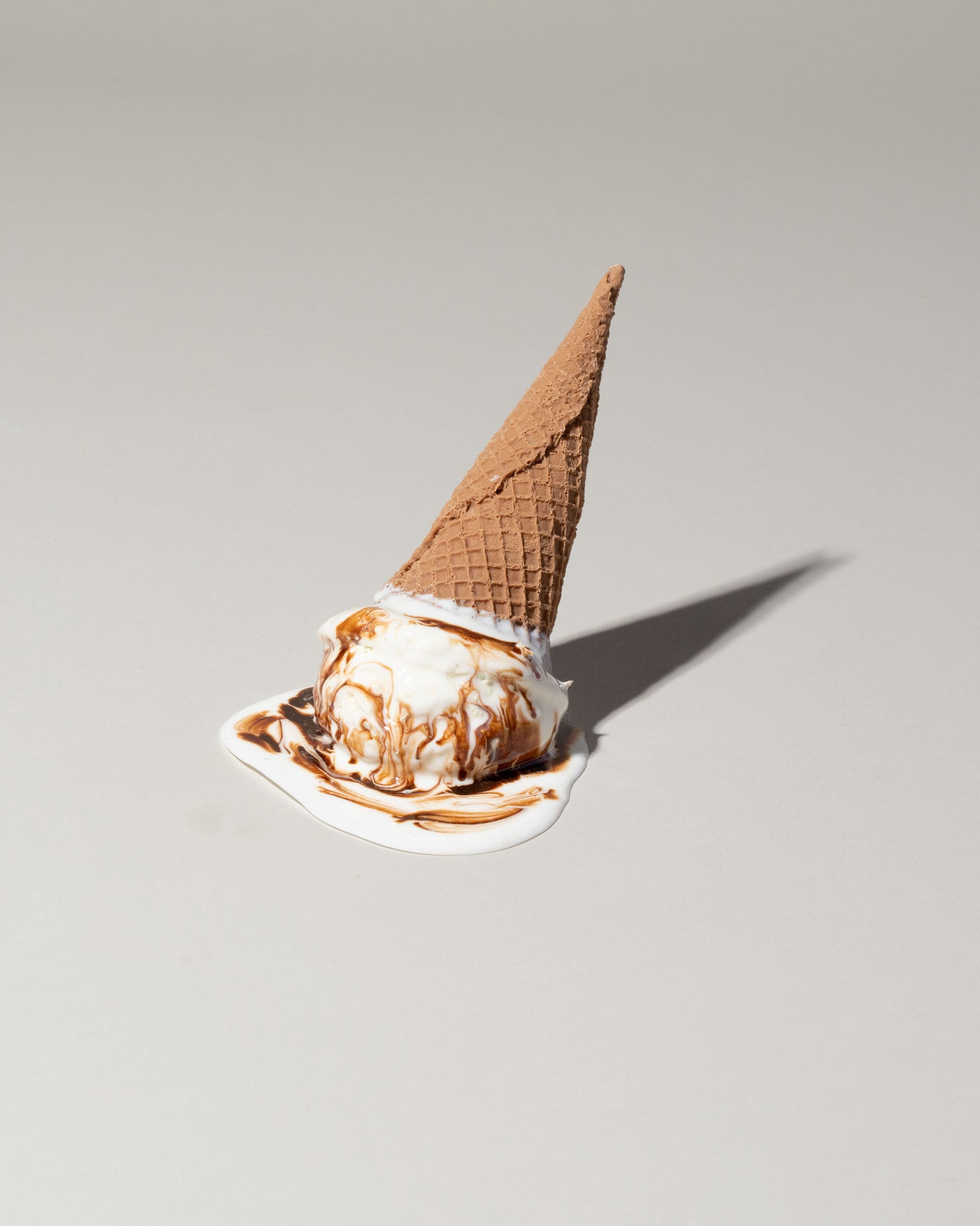 Spills Faux Chocolate Ice Cream Cone Spill on light color background.