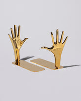 Carl Auböck Pair of Jazz Hands Brass Bookends Set on light color background.