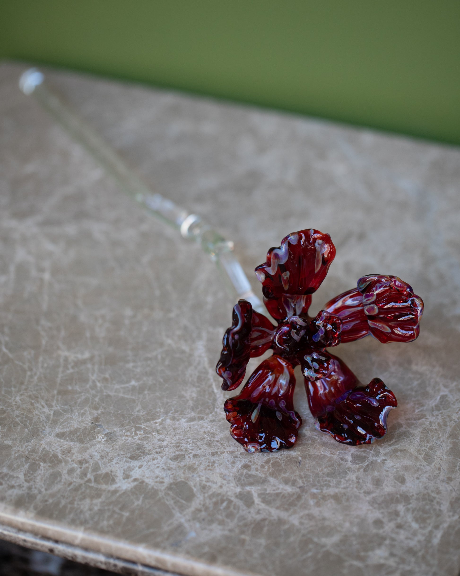 Alex Rosenbaum Red Glass Flower on green background.