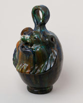 View from the side of the Apotropaia Head Flask on light color background.