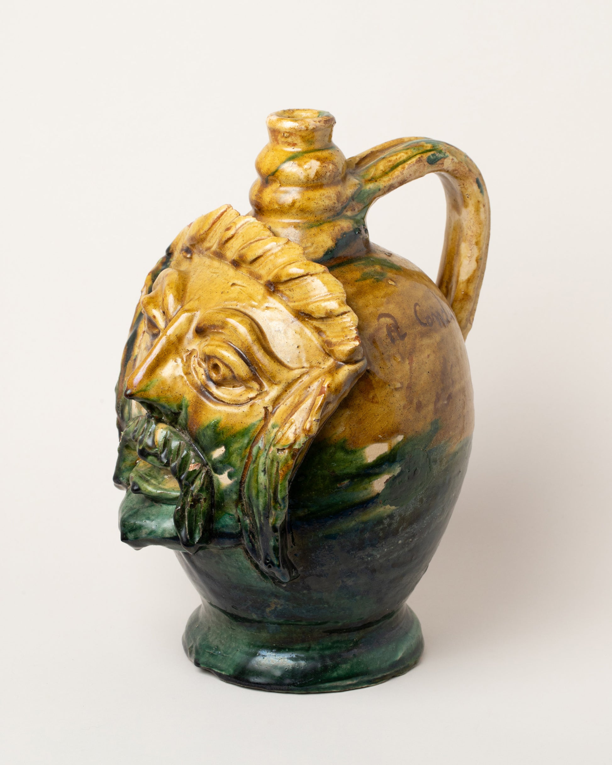 View from the side of the Apotropaia Large Head Jug Two on light color background.