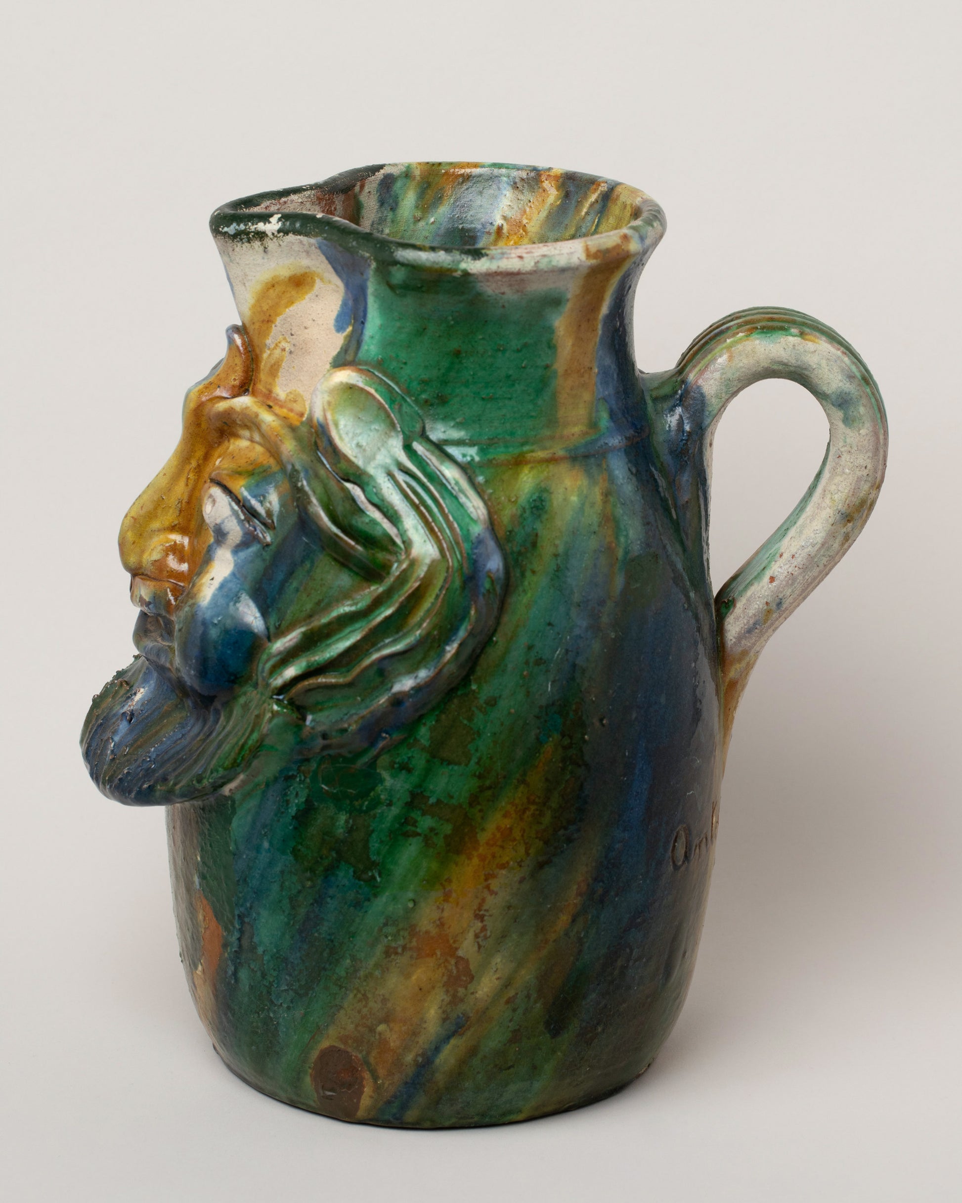 View from the side of the Apotropaia Large Head Pitcher on light color background.