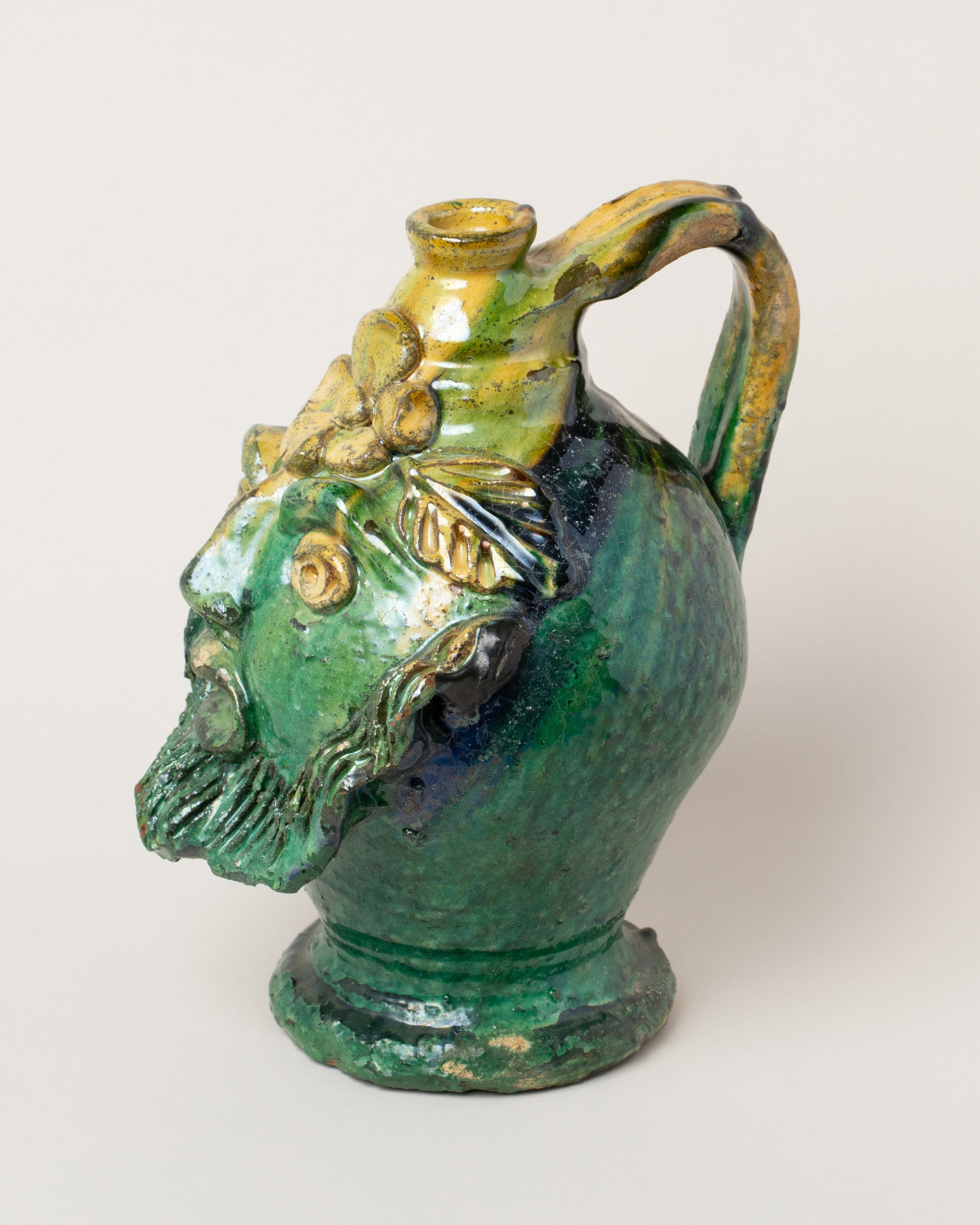 View from the side of the Apotropaia Small Head Jug on light color background.