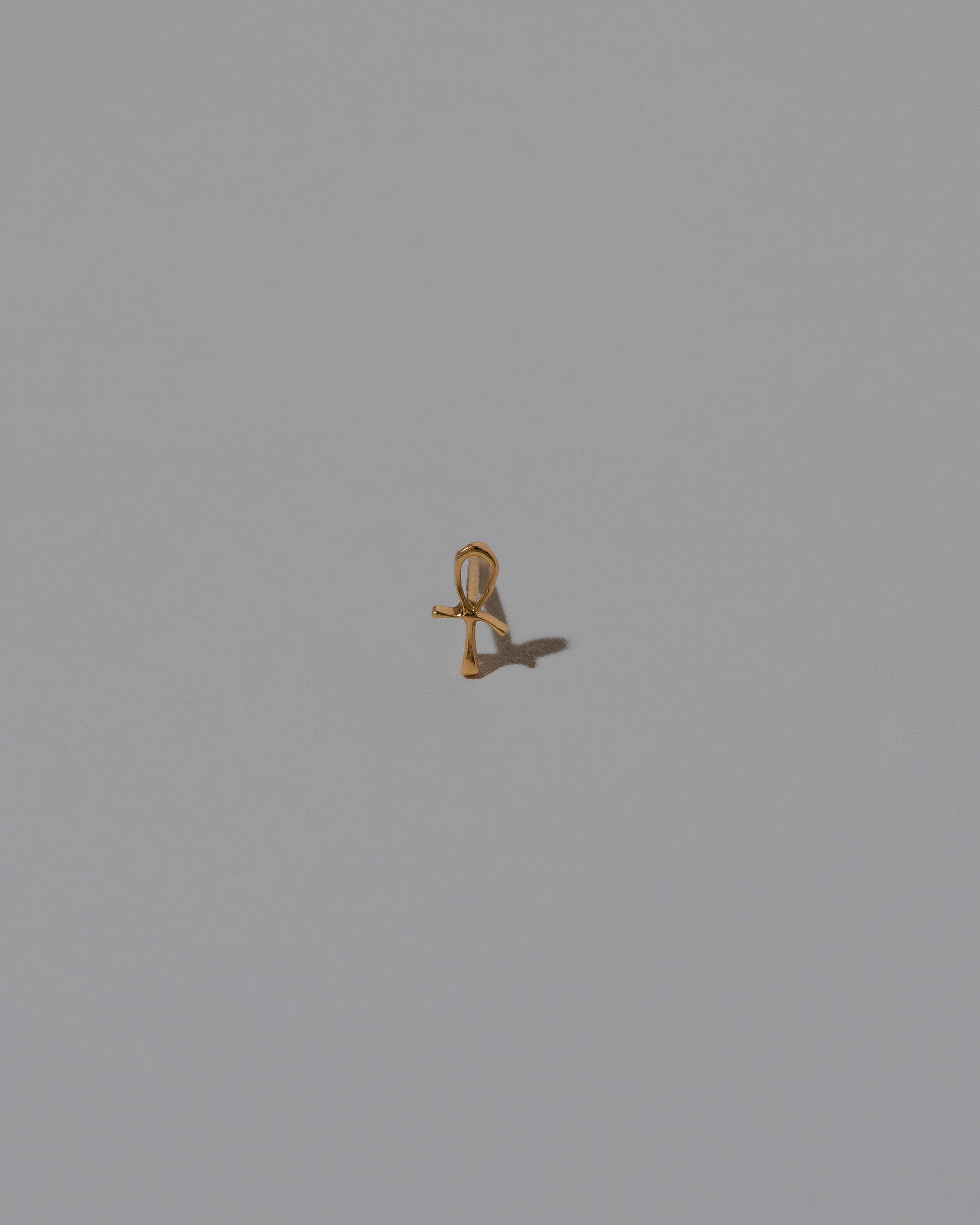 Closeup details of the Ankh Stud Earring Single on light color background.