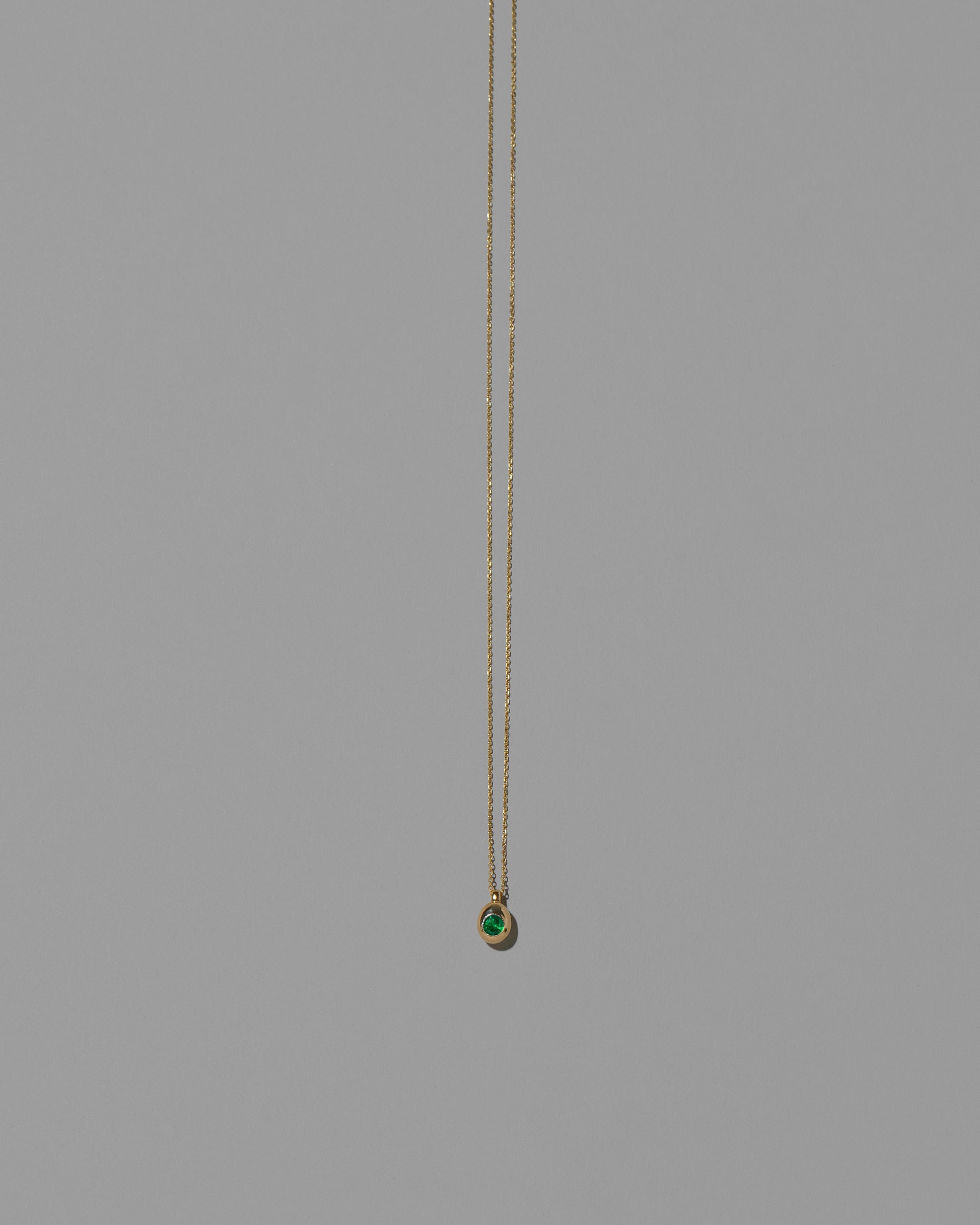 Emerald Birthstone Level Necklace on light color background.