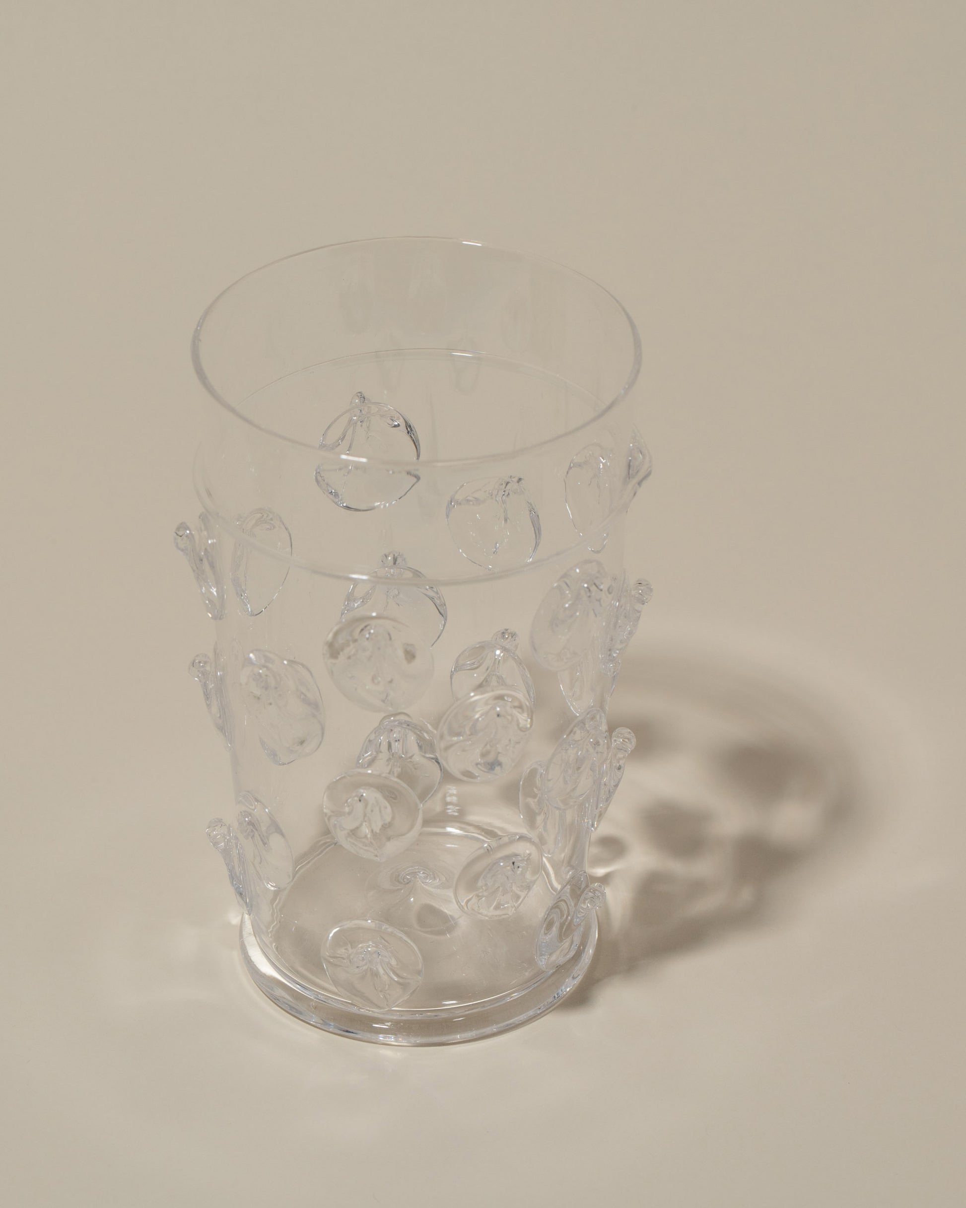 Closeup details of the Bollenglass Design Clear Dot Beer Glass on light color background.