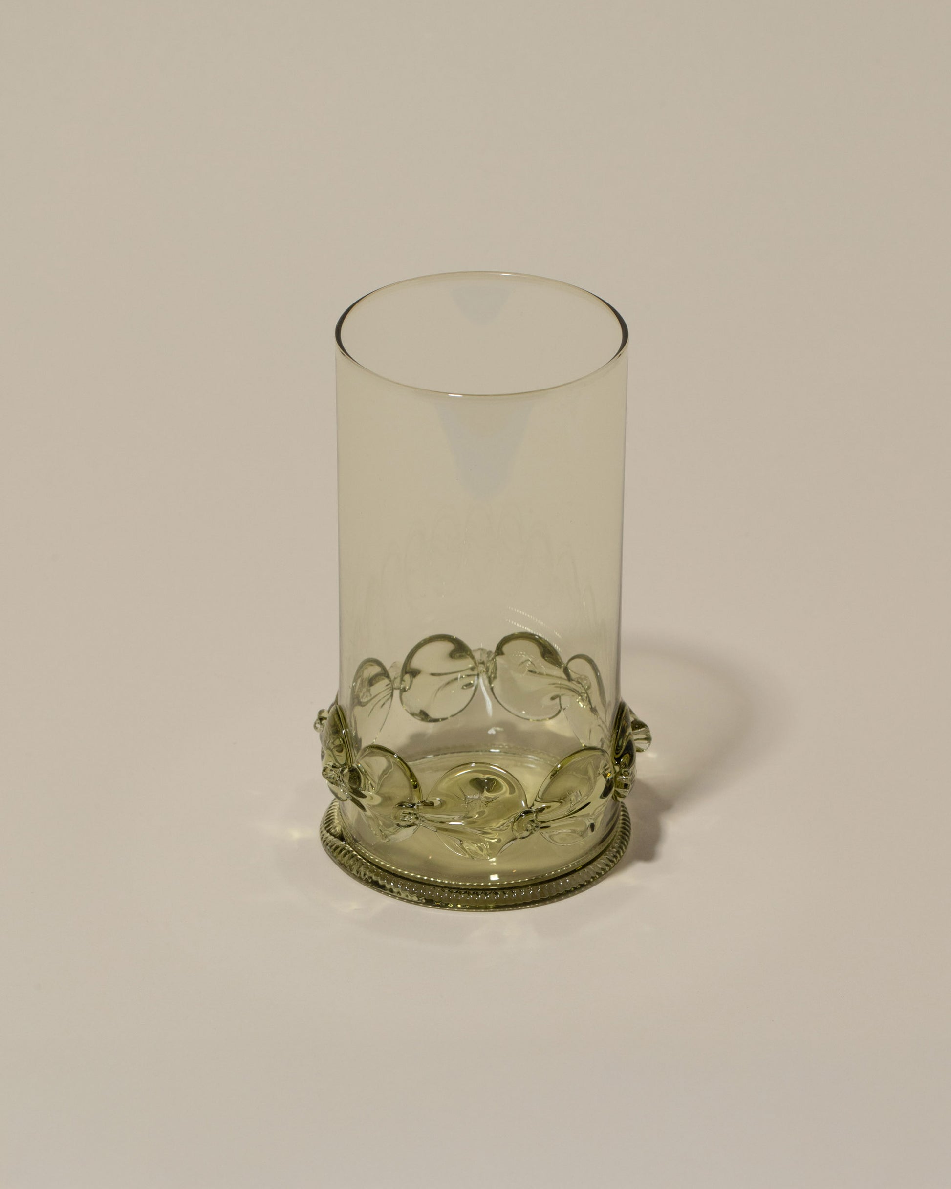 Closeup details of the Bollenglass Design Green Dot Highball Glass on light color background.