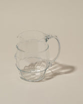 Closeup details of the Bollenglass Design Clear Petite Pitcher on light color background.