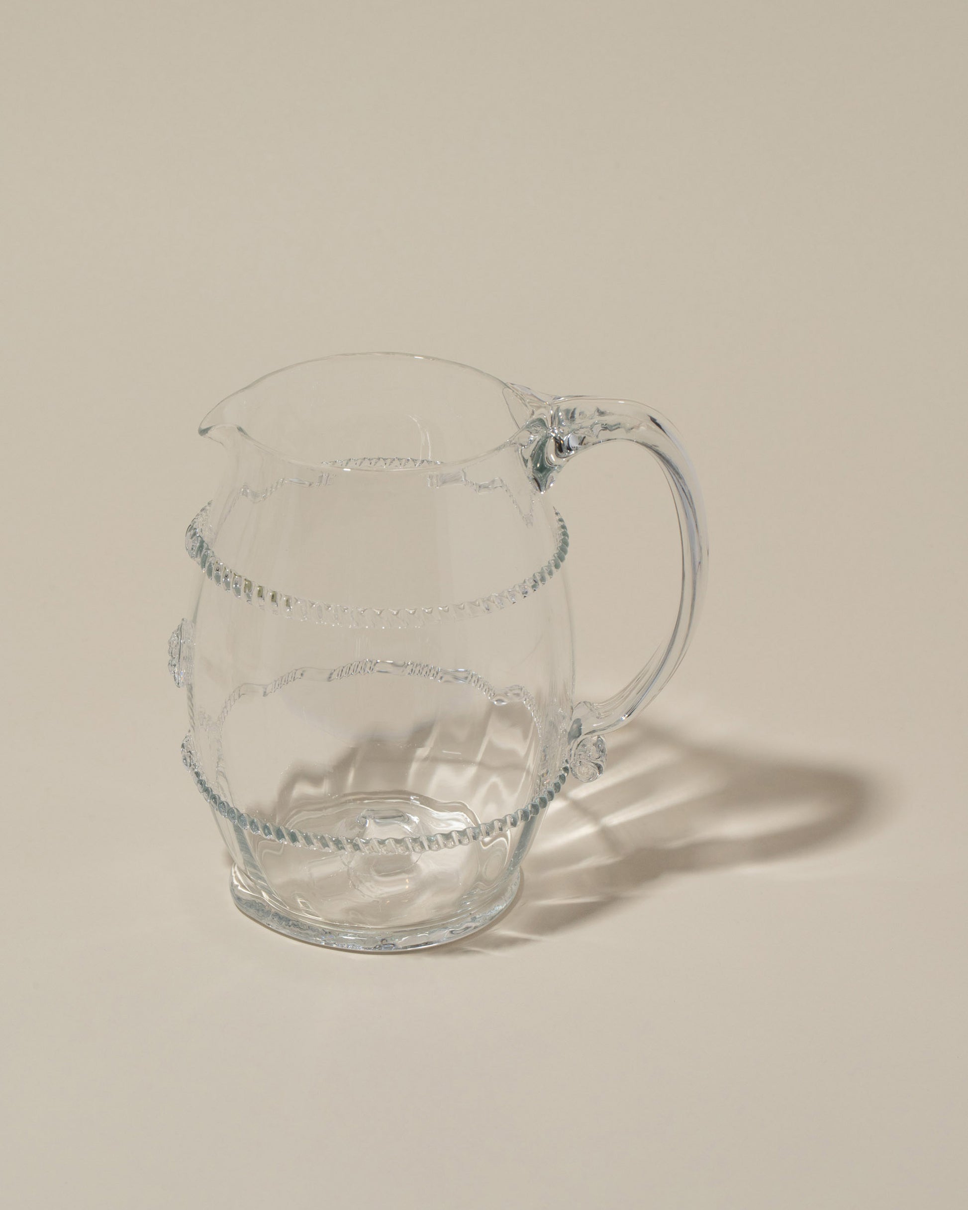 Closeup details of the Bollenglass Design Clear Petite Pitcher on light color background.