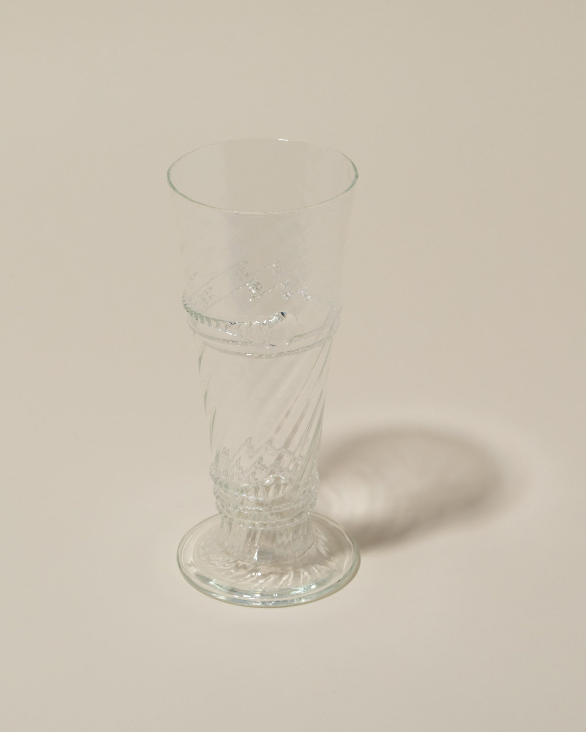 Closeup details of the Bollenglass Design Clear Small Spiral Tumbler on light color background.