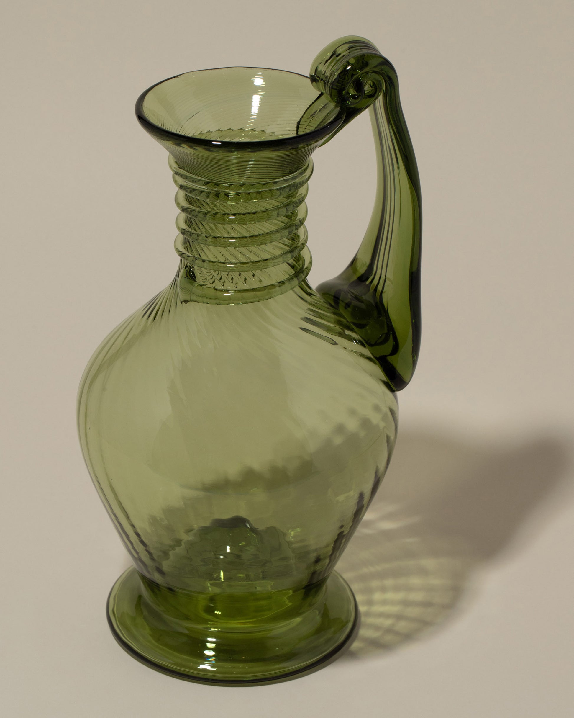Closeup details of the Bollenglass Design Green Spiral Jug on light color background.