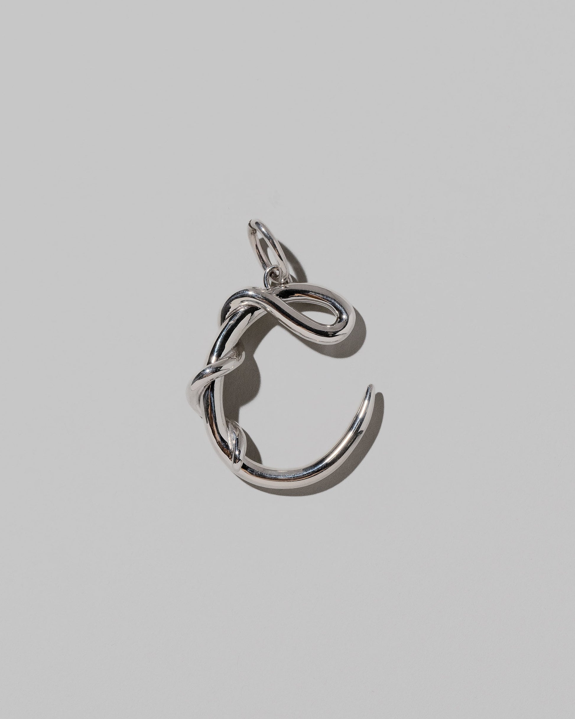 CRZM Sterling Silver Letter C Bag Charm on light color background.