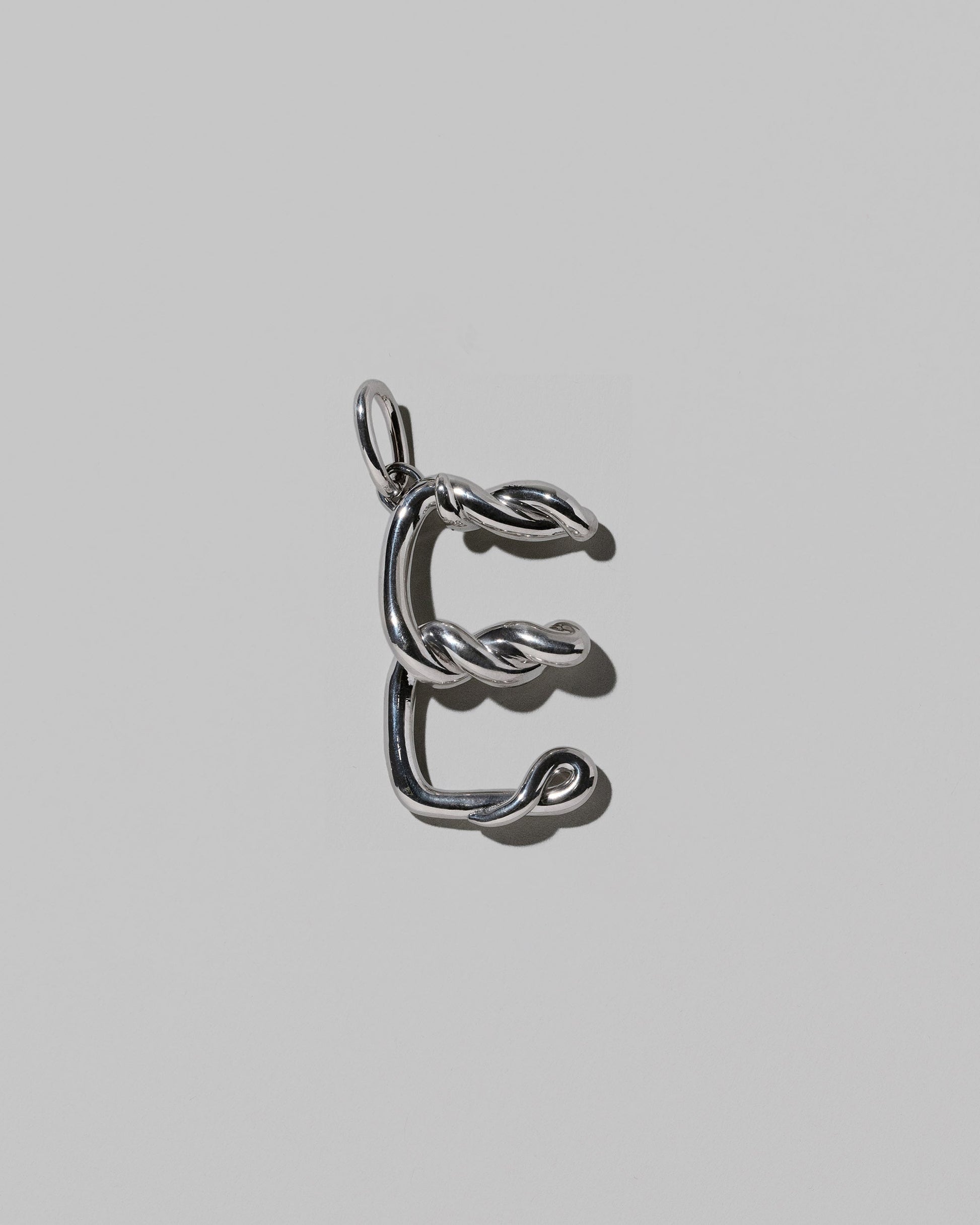 CRZM Sterling Silver Letter E Bag Charm on light color background.