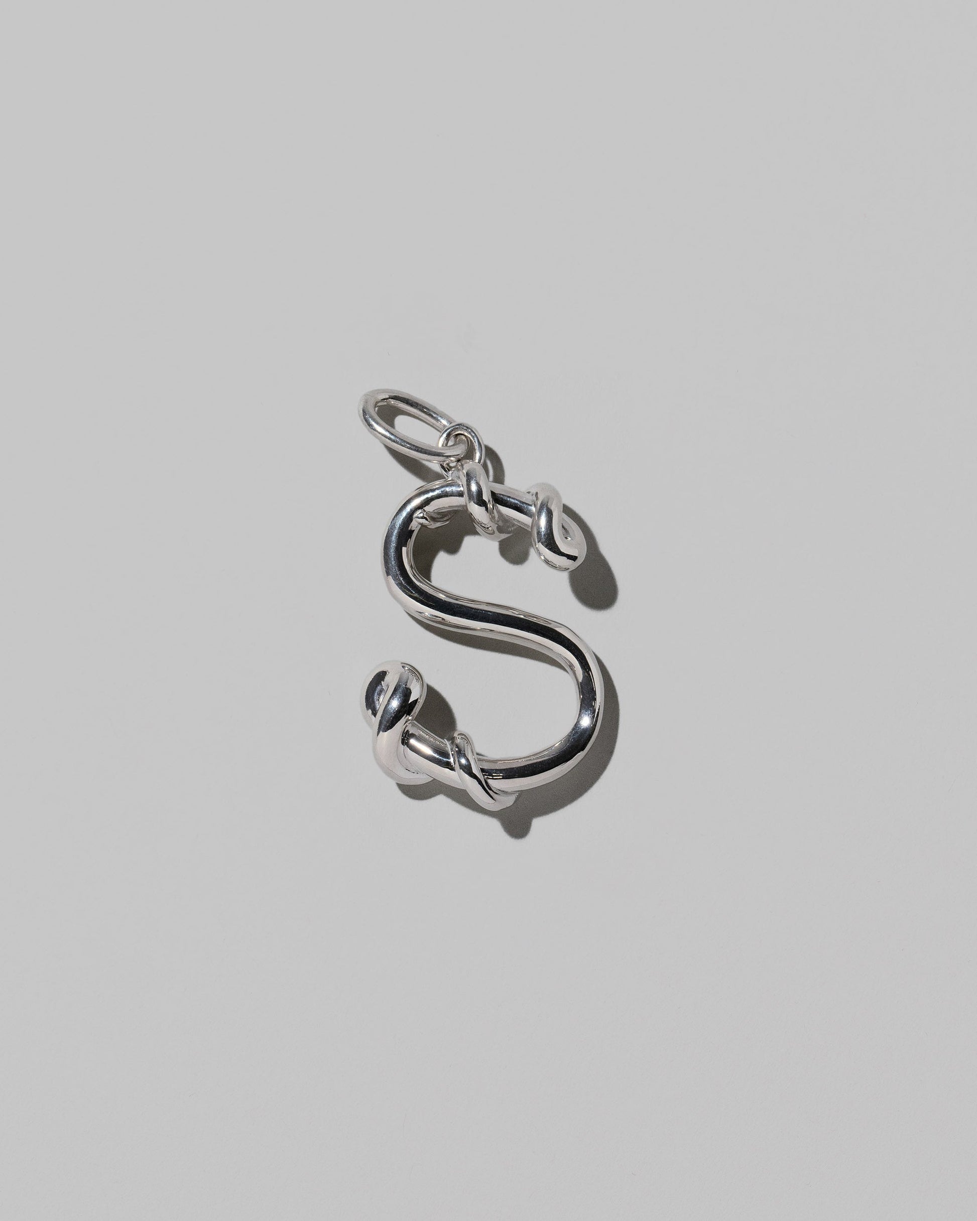 CRZM Sterling Silver Letter S Bag Charm on light color background.