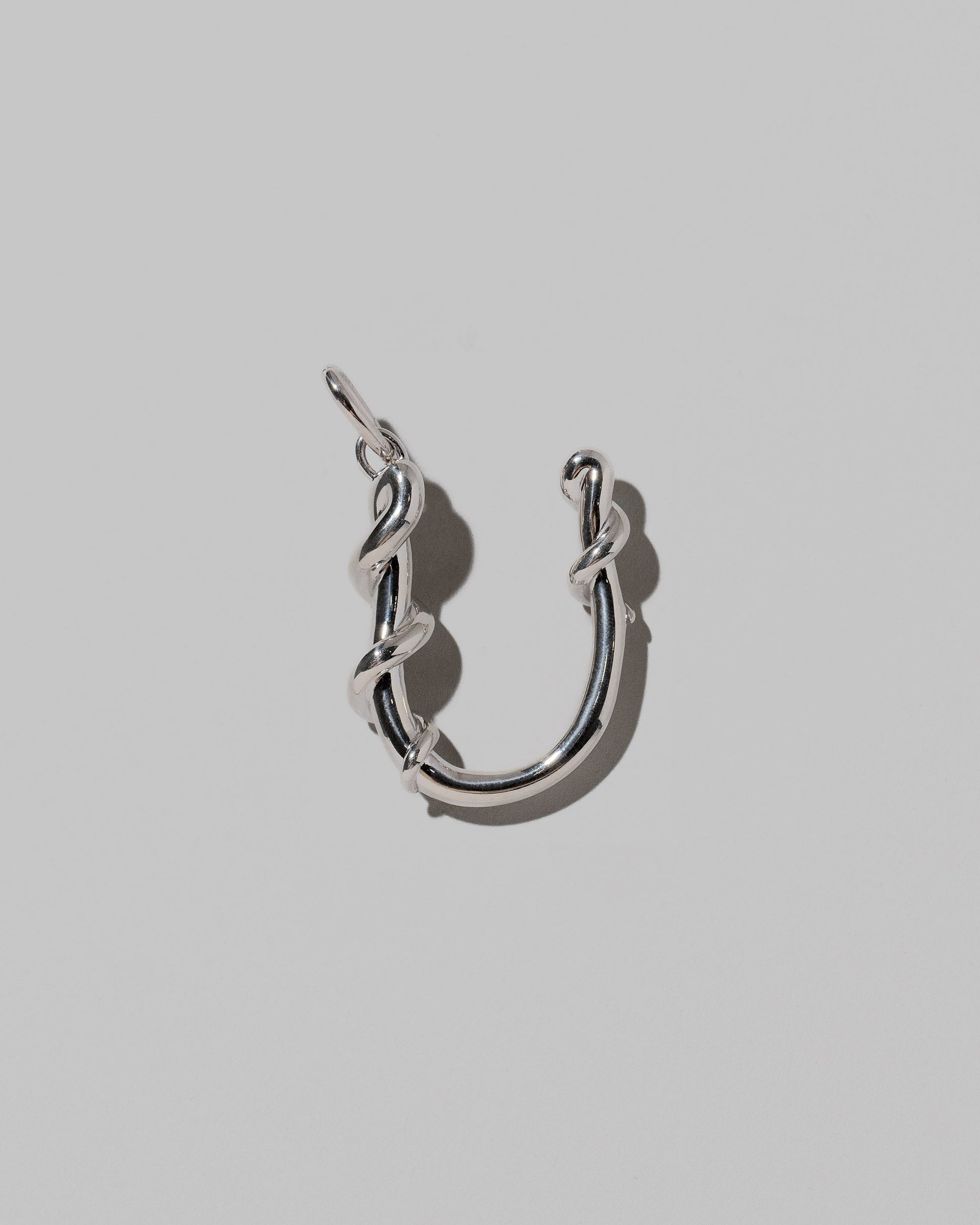 CRZM Sterling Silver Letter U Bag Charm on light color background.