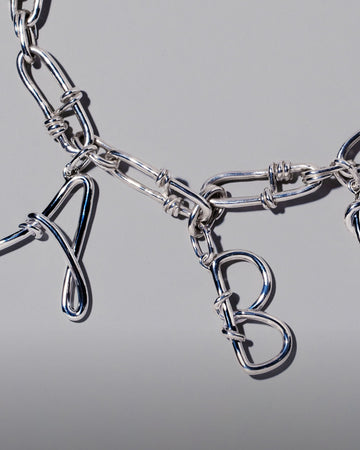 CRZM Large Sterling Silver Letter Charm A, CRZM Large Sterling Silver Letter Charm B and CRZM Sterling Silver Canyon Necklace on light color background.