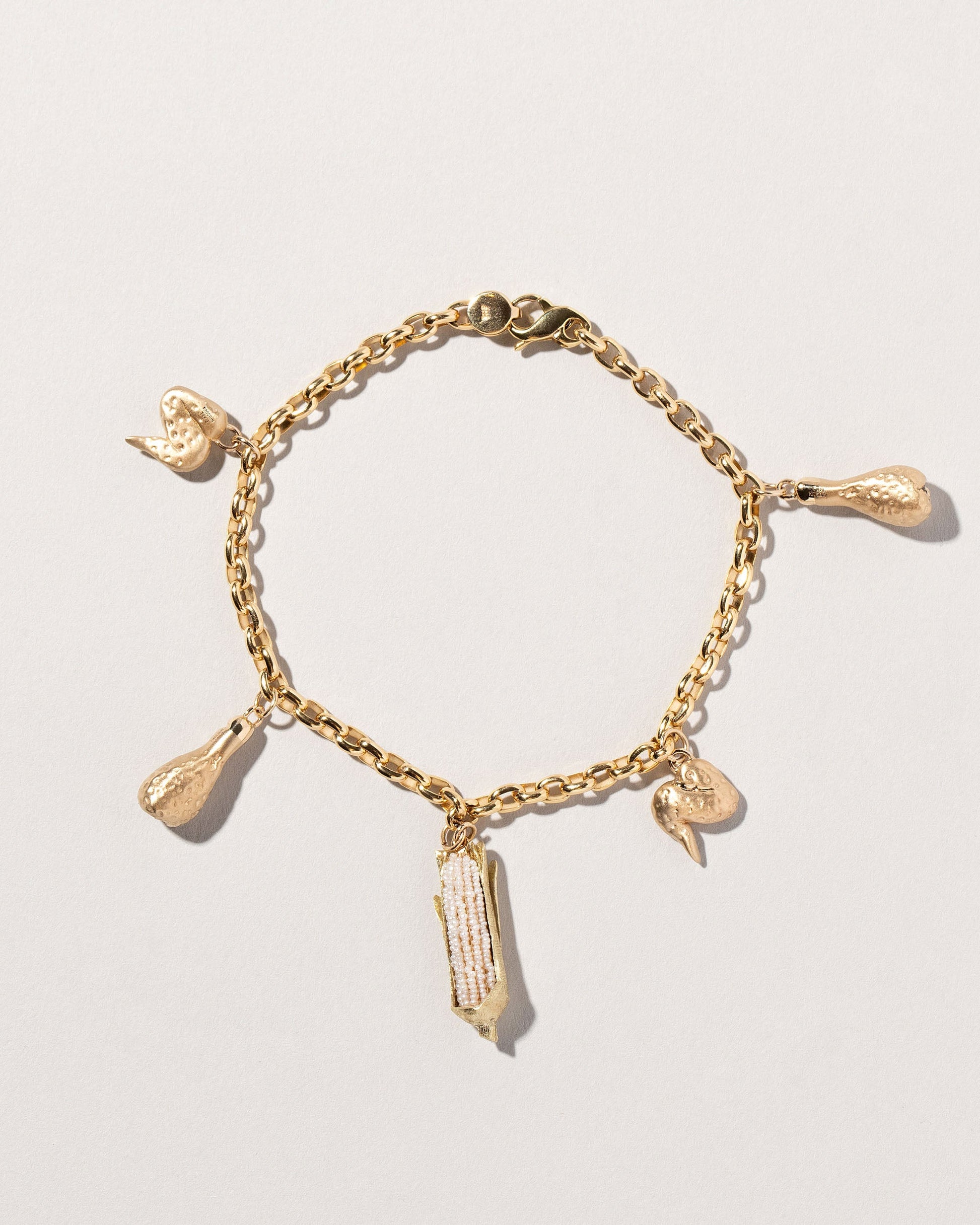 Chicken Drumstick Charm, Chicken Wing Charm and Corn on the Cob Charm with Gold Endless Clasp Bracelets on light color background.