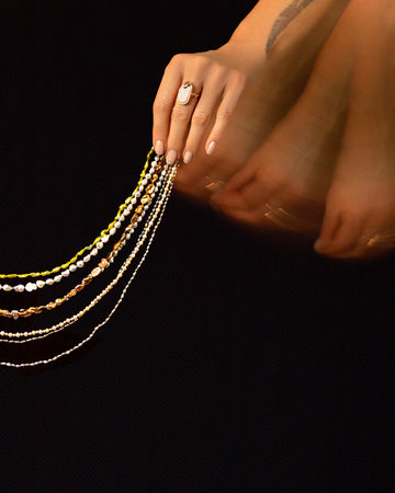 Styled long exposure image featuring the the Ula Pearl Necklaces on dark color background.