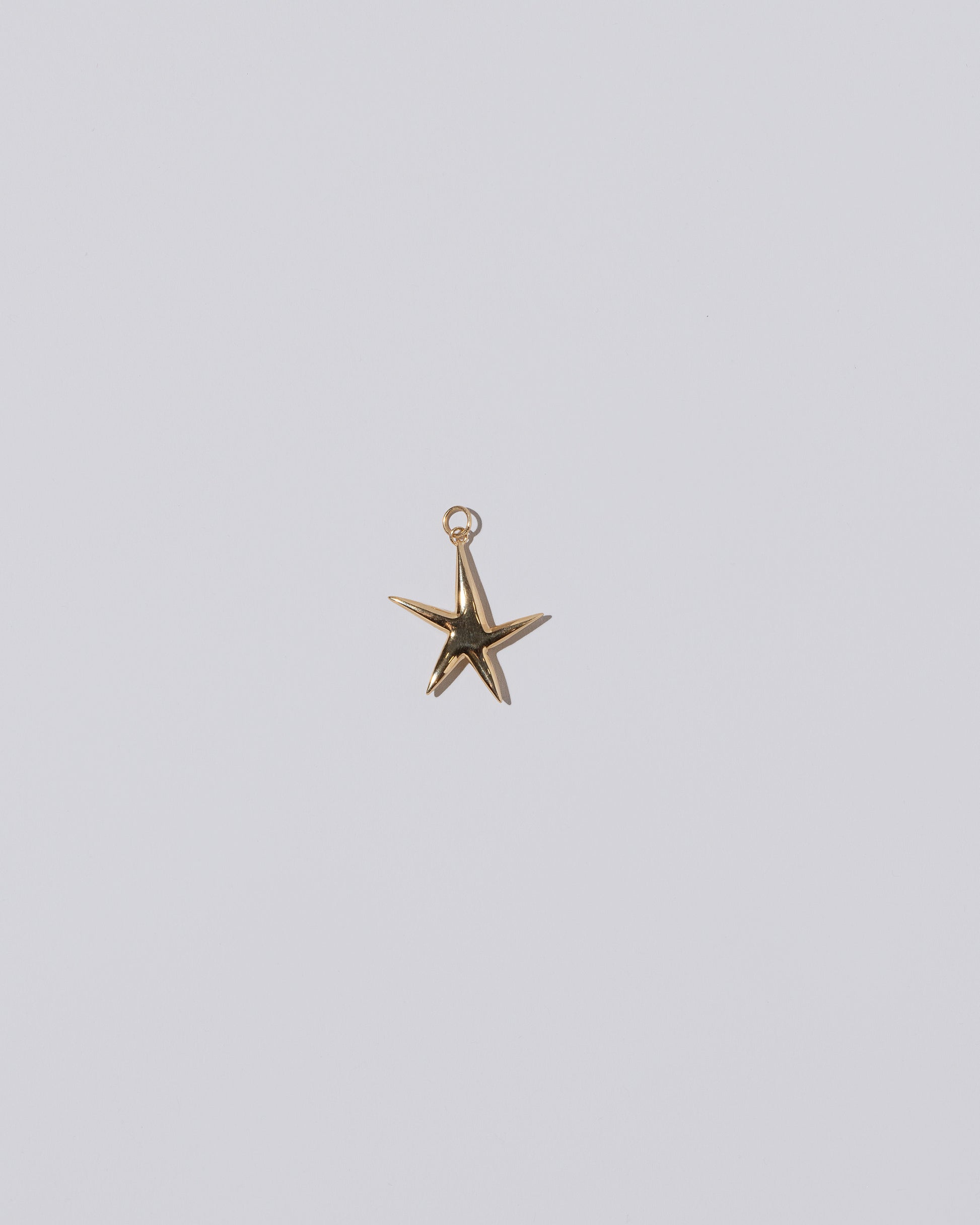 Verve Five Point Star Charm on light color background.