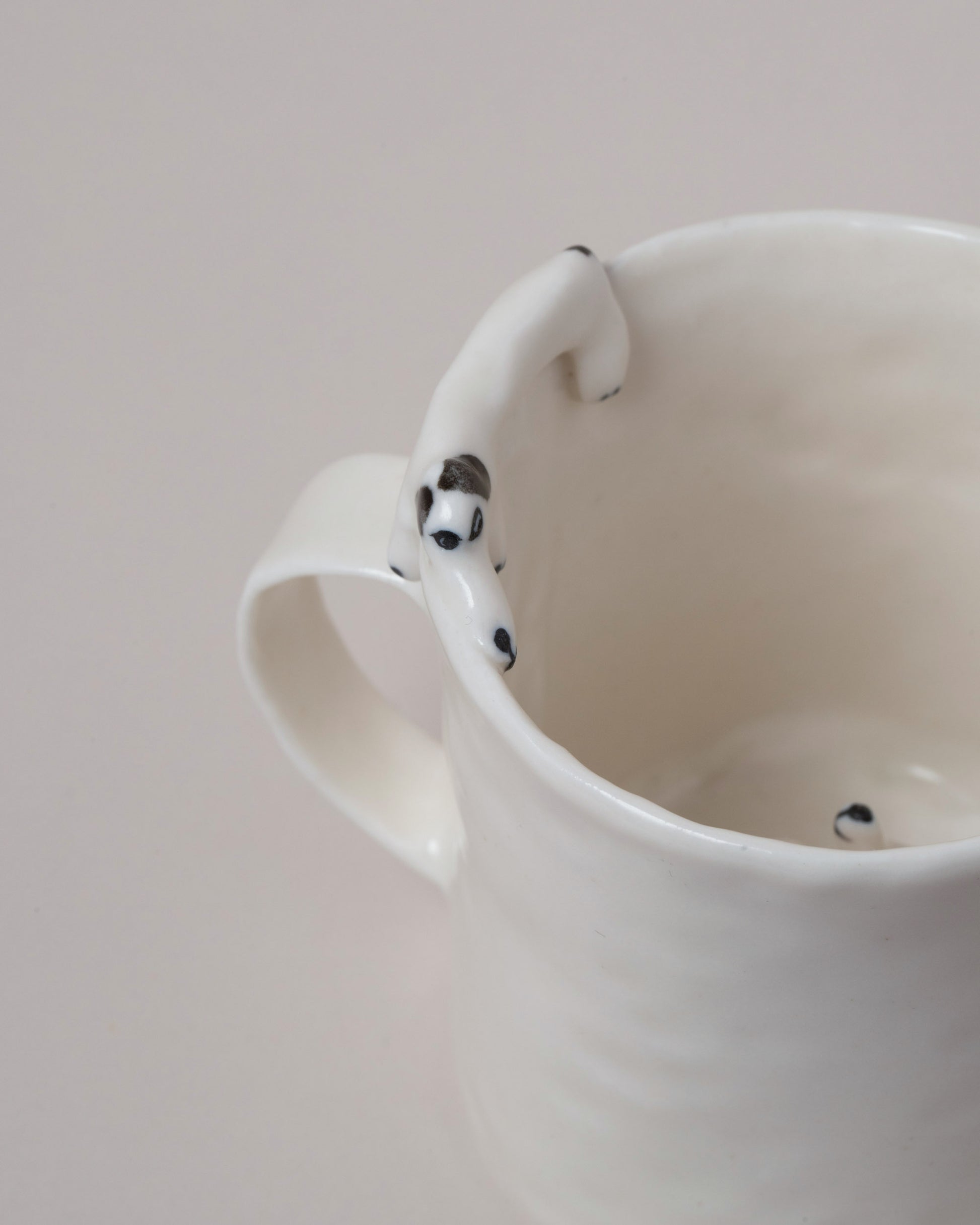 Closeup details of the Eleonor Boström Hiding Dog Mug on light color background.