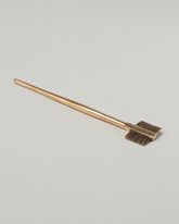 Pearce Objects Cast Bronze Eyebrow Brush on light color background.