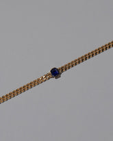 Closeup details of the Gold Blue Sapphire Fold Bracelet on grey color background.