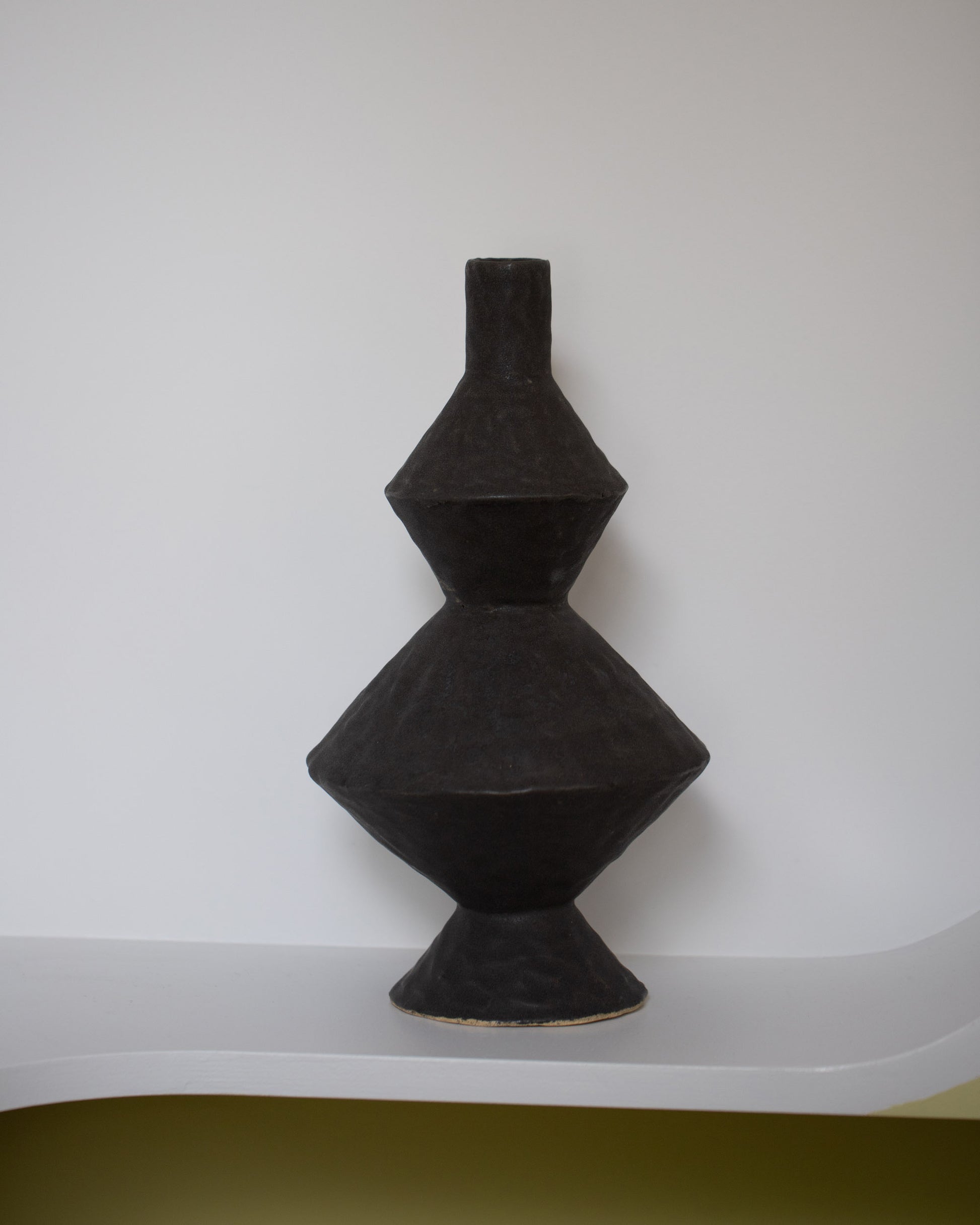 Giselle Hicks Soft Black Zig Zag Bottle on light color background.